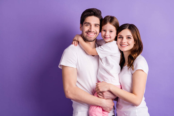 Portrait of nice cheerful careful loving family mommy daddy offspring daughter wearing casual embracing harmony idyllic isolated on bright vivid shine vibrant violet color background - Foto, Imagem
