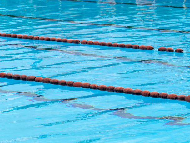 水泳プールの詳細:水泳レーンマーカーとして使用されるヴィンテージコルクフロート;澄んだ水 - 写真・画像