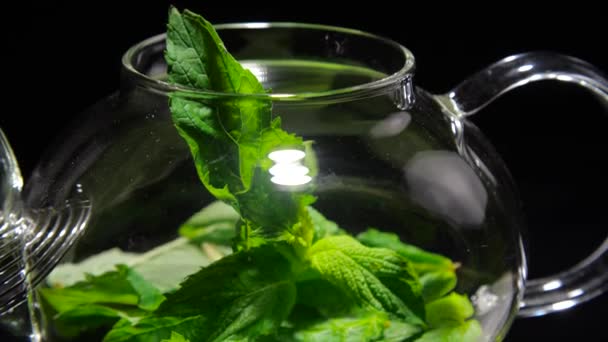 Teapot herbal tea with mint on a black background - Footage, Video