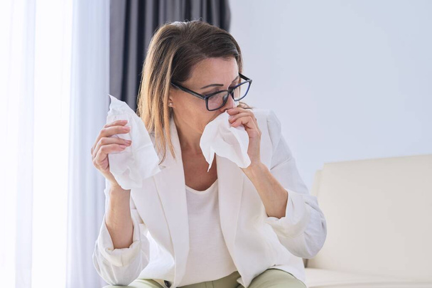 Woman sneezes in handkerchief, businesswoman got sick in the office - Fotoğraf, Görsel