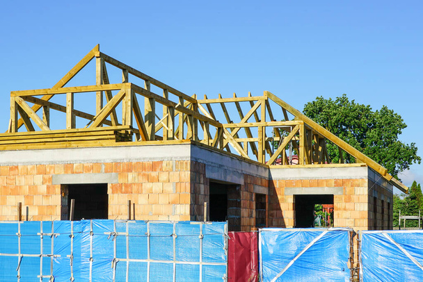 Bau einer neuen Wohnhaus-Dachkonstruktion vor blauem Himmel - Foto, Bild