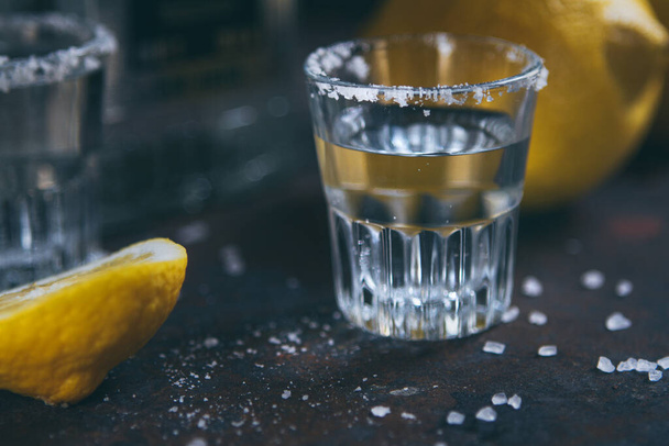 A glass of alcoholic drink decorated with coarse salt, with lemon - Фото, изображение