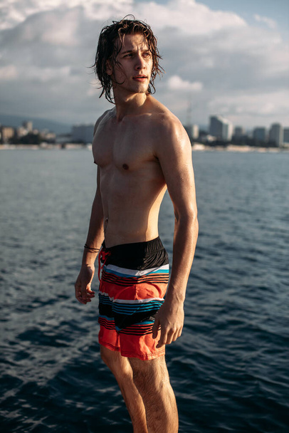Young caucasian hipster guy enjoying journey on yacht deck sailing the sea. - Fotó, kép