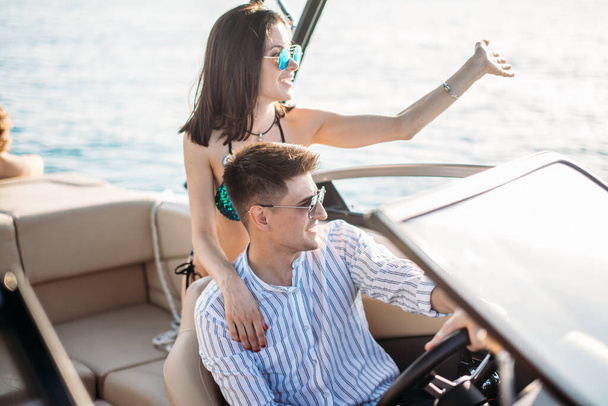 Young married couple having sea excursion on motor boat - Foto, imagen