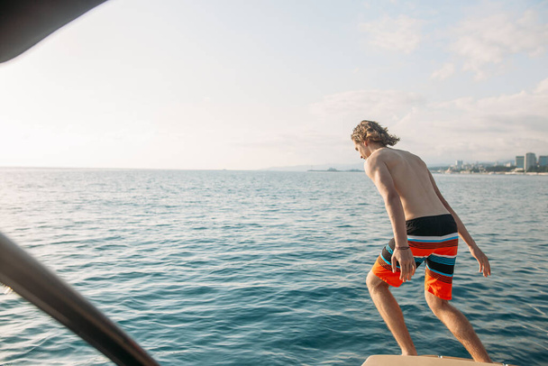 friends jumping in the water from the boat. leisure and fun - 写真・画像