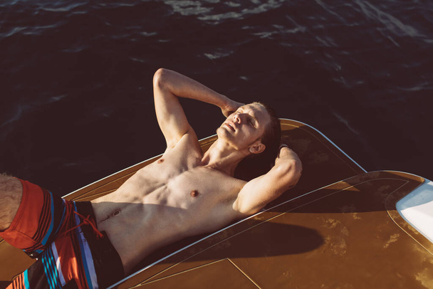 Young caucasian hipster guy enjoying journey on yacht deck sailing the sea. - Valokuva, kuva