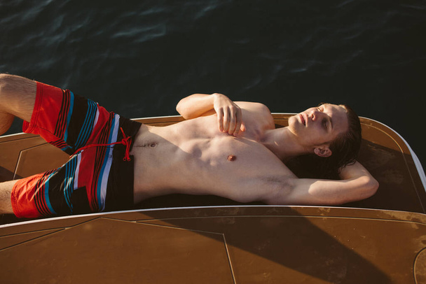 Young caucasian hipster guy enjoying journey on yacht deck sailing the sea. - Foto, immagini