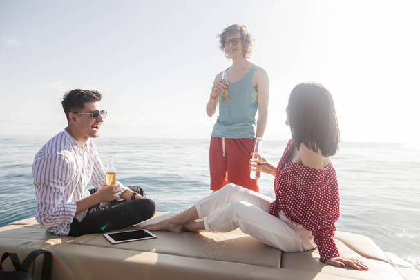yacht drinking beers while talking Group of friends having party on sailing boat - Foto, Bild