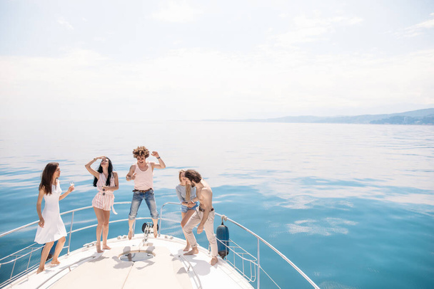 Marine cruise and vacation - youngsters with champagne glasses on boat or yacht - Foto, Bild