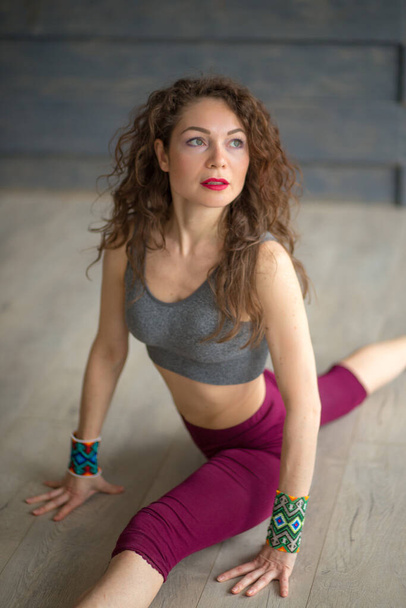 beautiful young woman sitting on the splits in the gym - Φωτογραφία, εικόνα