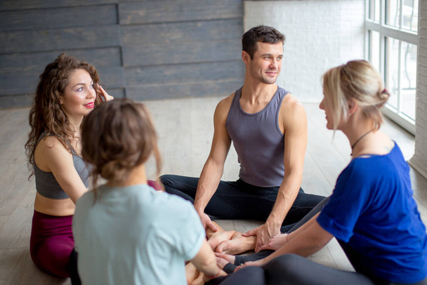 Mid aged attractive yogi sitting in circle sharing positive energy and emotions. - Photo, Image