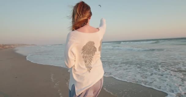 Slow motion vrouw genieten van de natuur, kijken naar vliegende vogel over het water, 4K - Video