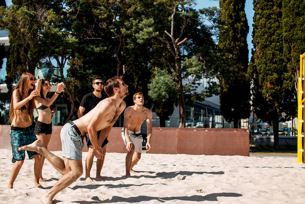 grupa młodych ludzi grających w siatkówkę na plaży - Zdjęcie, obraz