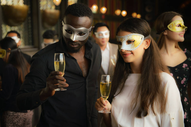 diverse businesspeople african american businessman and caucasian businesswoman having fun together in corporate mask party in business club and lounge - Foto, immagini