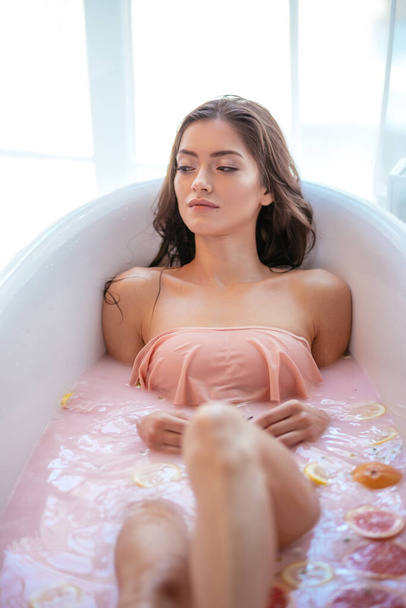 Woman relaxing in milky bath in spa resort. Wellness and Wellbeing concept - Фото, зображення