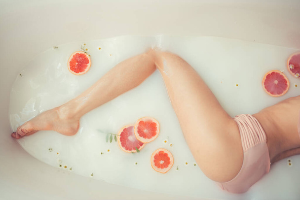 beautiful sexy woman in the milk bath with flowers - Foto, imagen