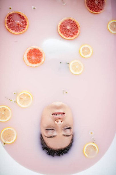 woman face in milk bath. Spa skin care concept. Healthy Face and rejuvenation. - Photo, Image