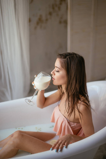 Sensual attractive woman relaxing in bath with glass of milk. - Φωτογραφία, εικόνα