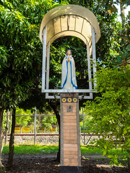 Статуя Девы Марии с пластиковым листом на вершине для дождя в Медельине, Антиокия / Колумбия - Фото, изображение