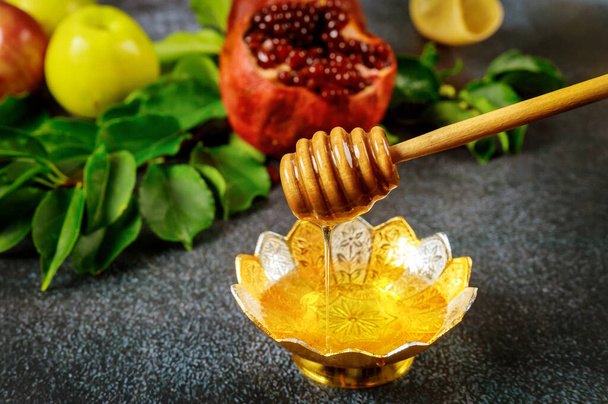 Luonnollinen makea hunaja puinen hunaja tikku ja granaattiomena. - Valokuva, kuva
