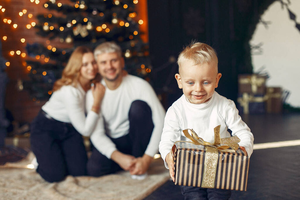 Family with little son at home near christmas tree - Foto, Imagem
