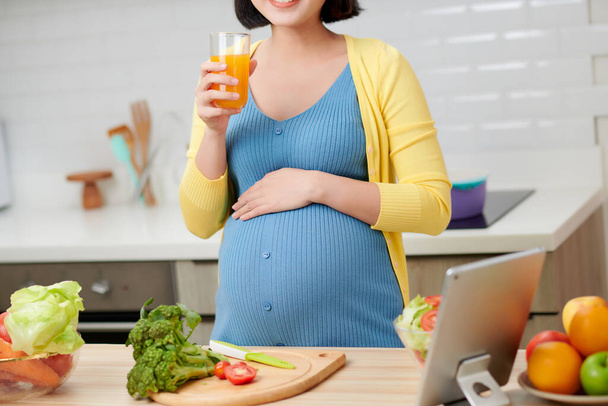 donna incinta in cucina bere succo di frutta sano - Foto, immagini