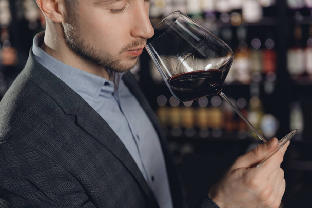 Winemaker sommelier smelling red wine aroma in glass - Foto, afbeelding