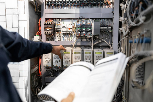 Arbeiter-Ingenieur überprüft Elektriker-Messungen mit Tester-Multimeter für industrielle Produktion - Foto, Bild