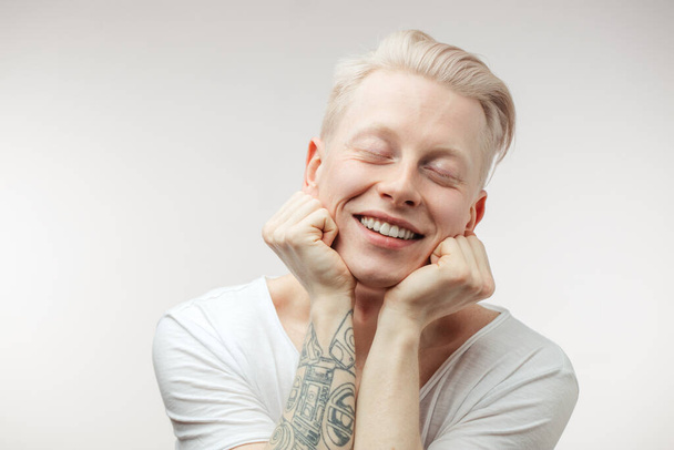Hipster guy with blond hair smiling having cheerful look. Positive emotions - Fotoğraf, Görsel
