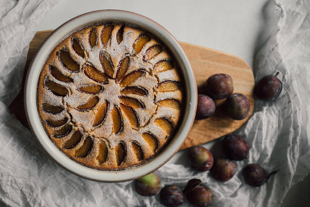 Delicious plum homemade tart from organic ingredients. Tasty and healthy dessert flat lay with beautiful food styling. Home baking passion with season fruits. A sweet dish from eco plums and polenta. - Fotoğraf, Görsel