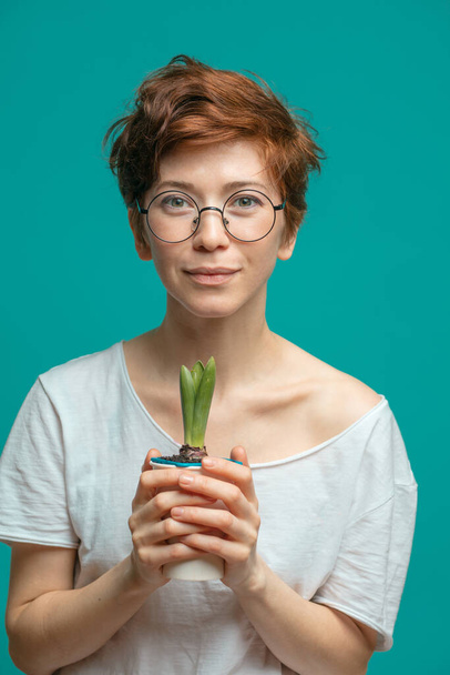 Caucasian woman with ginger hair posing with potted flower - Fotografie, Obrázek