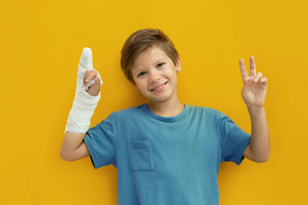 A child with a plaster on his hand. Copy space - Zdjęcie, obraz