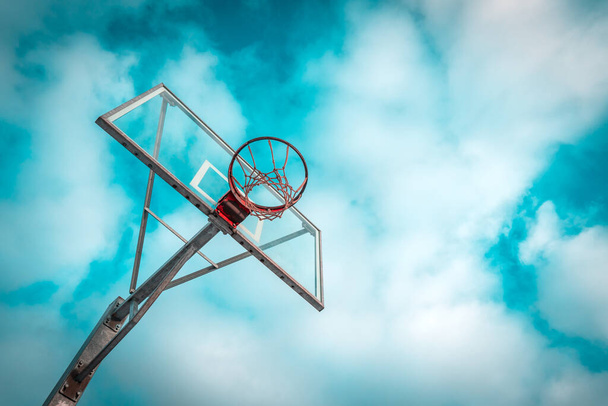 Outdoor basketball game concept. Basketball net against the blue sky with clouds. - Фото, зображення