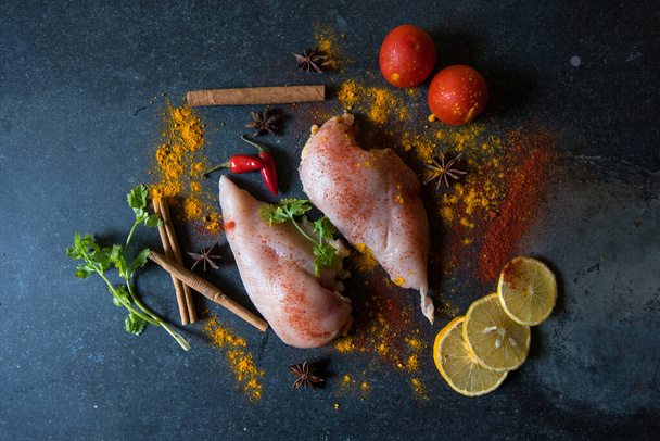 Filetes de peito de frango crus com verduras e temperos em um contexto. - Foto, Imagem