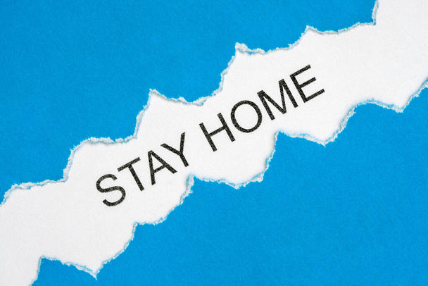 Stay at home concept. Torn paper with words STAY HOME  on a white background. Coronavirus, COVID-19, self-quarantine, isolation - Foto, afbeelding