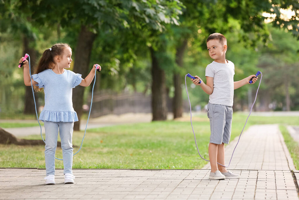 Schattige kleine kinderen springen touw buiten - Foto, afbeelding