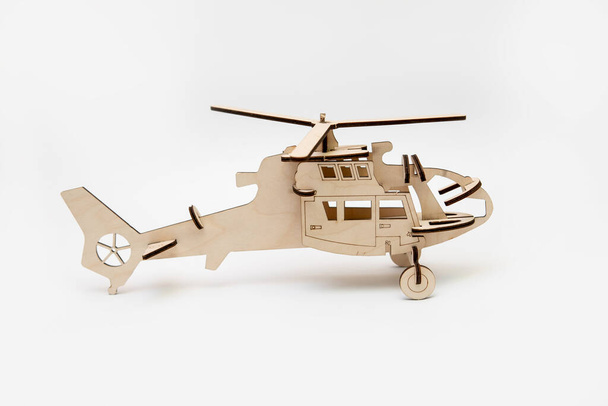 Modèle en bois d'un hélicoptère. Set de construction en bois pour enfants. Hobby et concept de loisirs - Photo, image