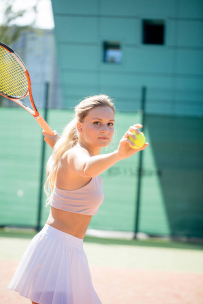 Woman serving the ball for a game of tennis on court - Fotografie, Obrázek