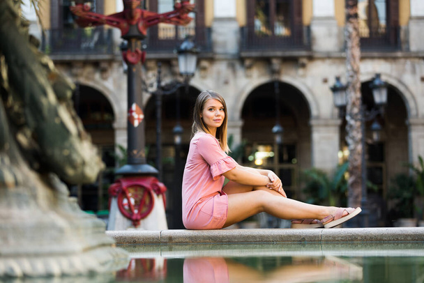 Girl sitting near fountain - Foto, Imagen