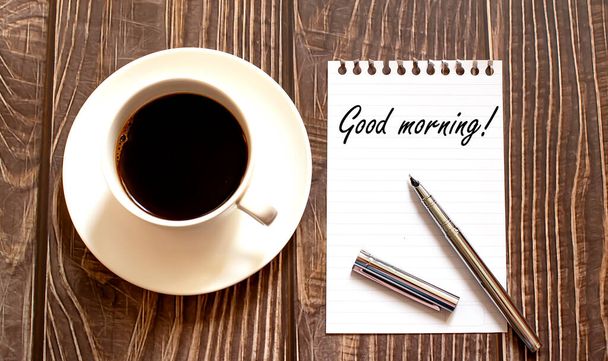 GOOD MORNING - weißes Papier mit Stift und Kaffee auf Holzgrund. Unternehmen - Foto, Bild