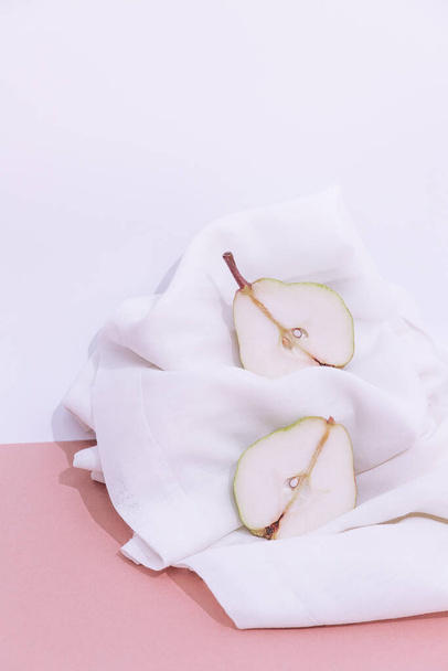 Fashion Still life composition with fresh pear on white textile background. Minimalist details aesthetic. - Zdjęcie, obraz
