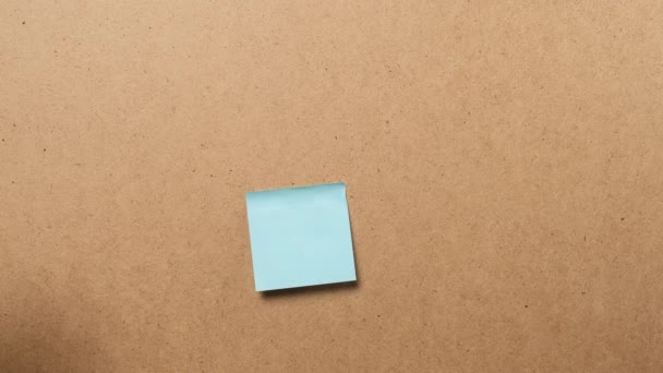 pegamento de mano femenina papel colorido pegatinas en blanco en tablero marrón, concepto de negocio, multitarea - Metraje, vídeo