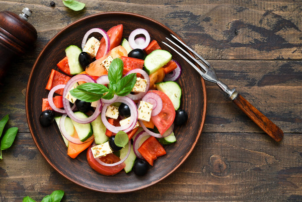 Classic Greek salad with feta on a wooden background. - Fotoğraf, Görsel