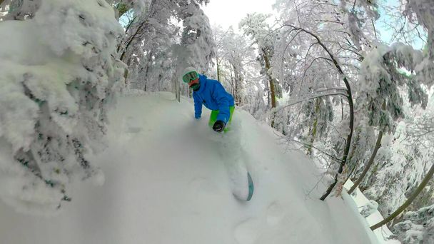 SELFIE: Extremo snowboarder masculino tallado en un peligroso bosque nevado en los Alpes. - Foto, Imagen