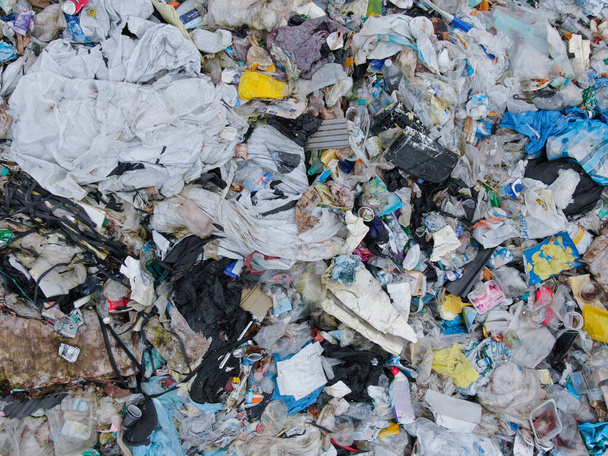 ARRIBA AERIAL: Volando por encima de una pila de basura en un gran basurero industrial. - Foto, Imagen