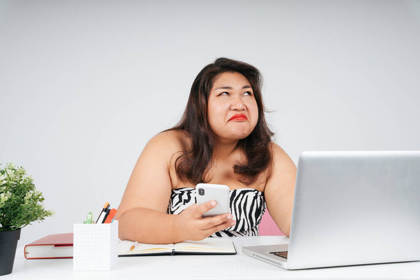 Rozrušený znuděný asijské baculatý žena na pracovní stůl v kanceláři, vzhlíží. - Fotografie, Obrázek