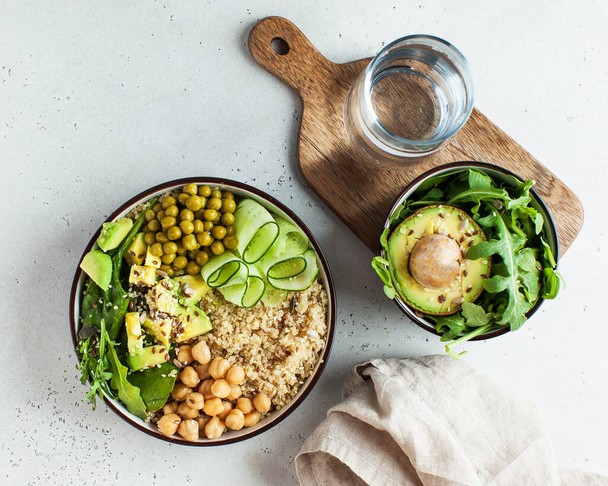 Healthy vegetable lunch from the Buddha bowl with quinoa, avocado, chickpeas, cucumber. The concept of a healthy food dish for vegetarians, a trend dish. High quality photo - Fotografie, Obrázek