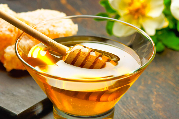 Honey background. Honey with wooden honey dipper on wooden table - Photo, Image