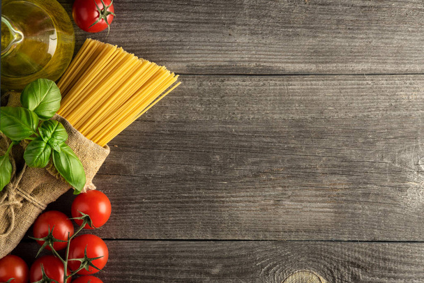 Pasta, verduras, hierbas y especias para la comida italiana sobre fondo negro, vista superior, espacio para copiar - Foto, imagen