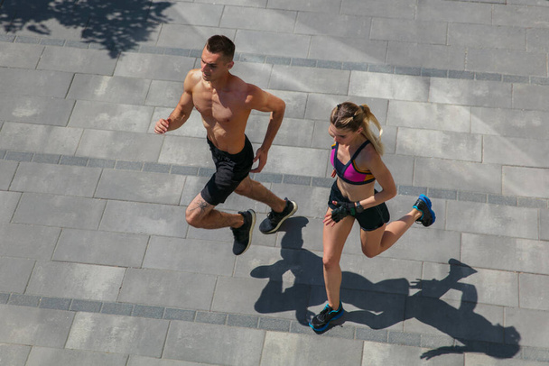 Young couple in sports outfit doing morning workout outdoors, healthy lifestyle - Photo, image